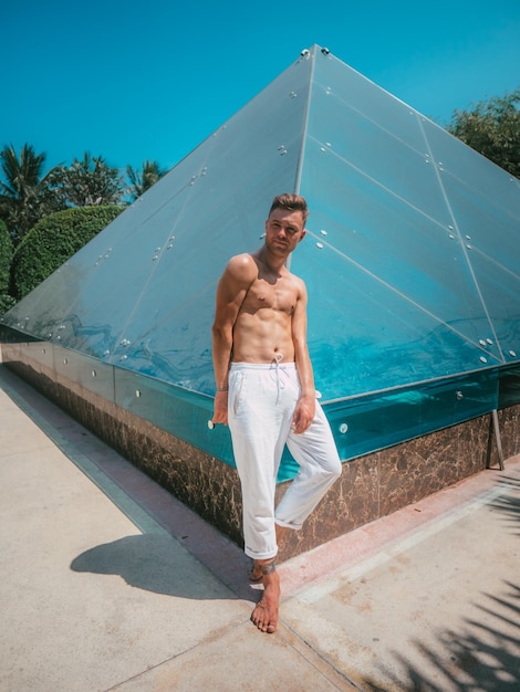 Photo male model in white pants on the beach