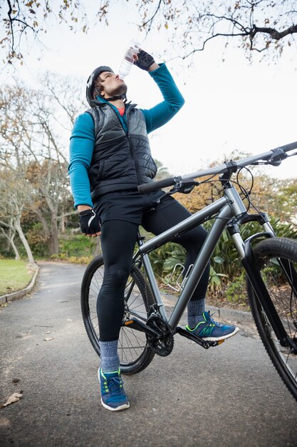 Male mountain biker drinking water