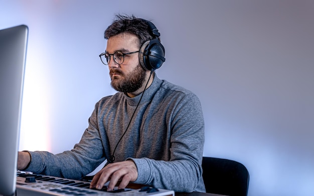 Male musician creates music using computer and keyboard musician workplace