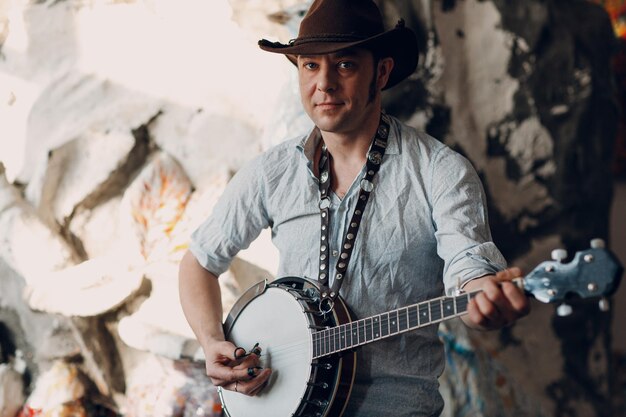 Male musician playing banjo sitting chair indoor