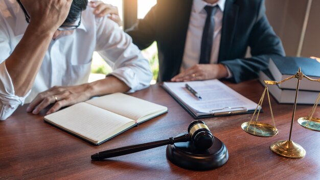 男性の公証人弁護士または裁判官が契約書に相談または話し合う