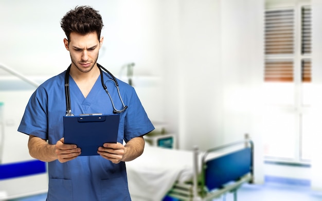 Male nurse isolated on whiteMale nurse reading a clipboard