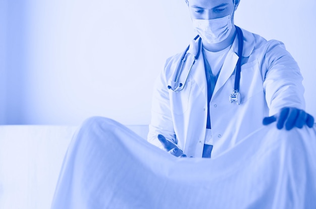 Male obstetrician and scrubs nurse are delivered to the pregnant woman in the delivery room of the hospital