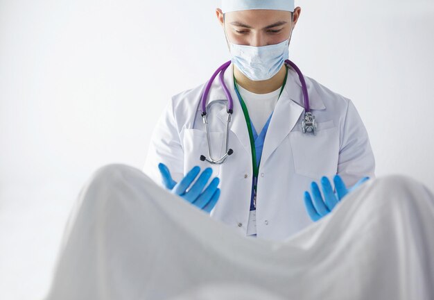 Male obstetrician and scrubs nurse are delivered to the pregnant woman in the delivery room of the hospital