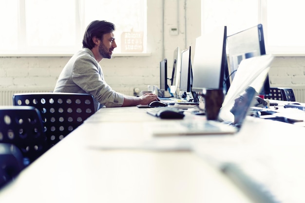 male office worker looking at computer screen with data