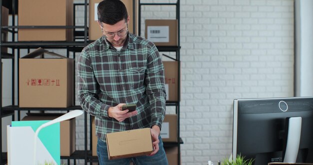 Male online store employee packs a package after