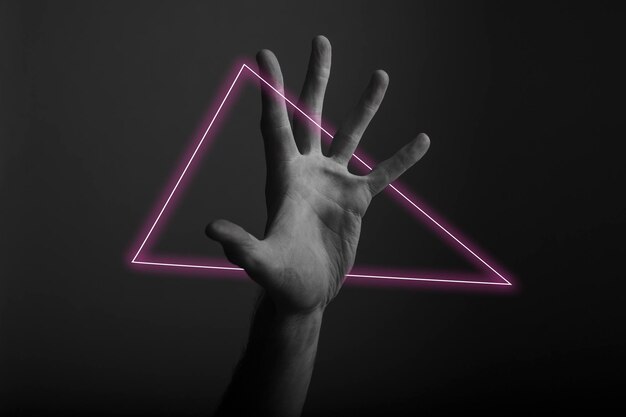 Foto gesto della mano aperta maschile su uno sfondo scuro con luce al neon astratta