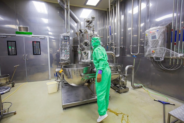 Male operation green protective clothes process in a food factory the processing production line in a factory