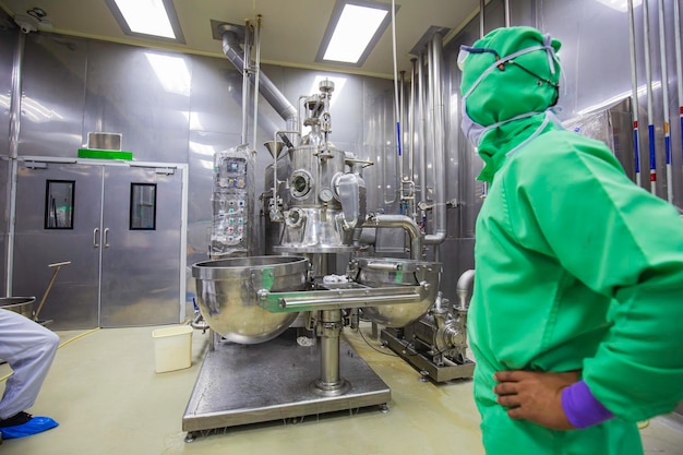 Male operation green protective clothes process in a food factory the processing production line in a factory