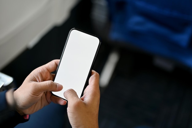 A male passenger using his smartphone during the flight smartphone white screen mockup