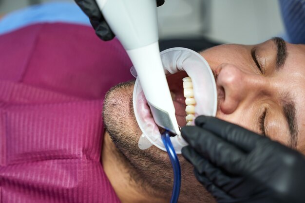 Male patient in detist office wearing plastic mouth dams