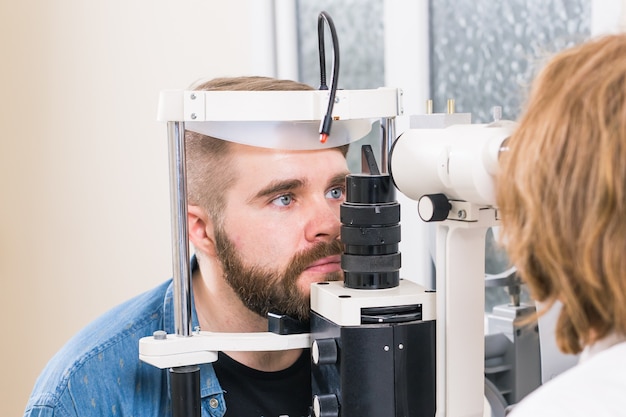 안과 의사가 자신의 시력을 확인하는 남성 환자