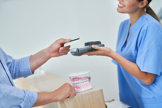 male patient paying for dental visit in clinic