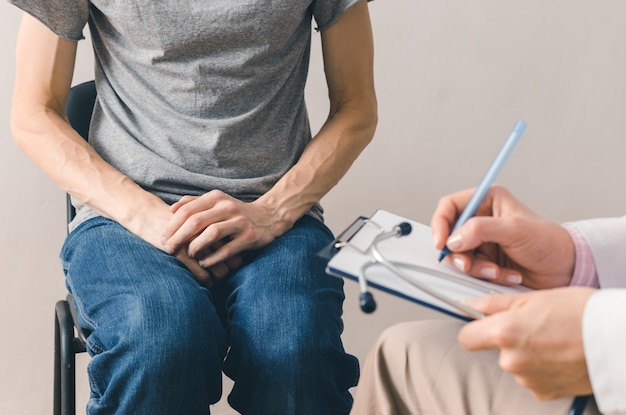 Male patient sits at the doctor's consultation. The problem of the prostate cancer. 