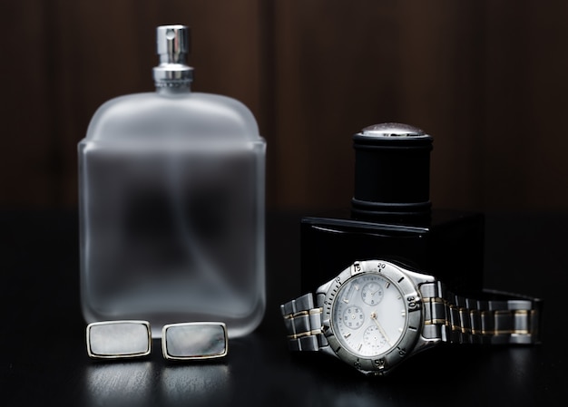 Male perfume and watches on a wooden. Men's Accessories