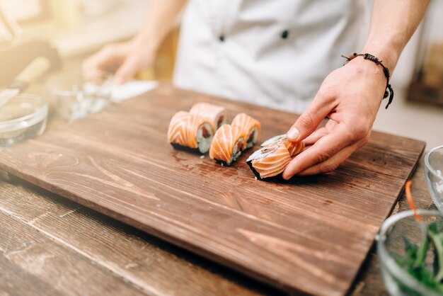 Male person cooking sushi, japanese kitchen