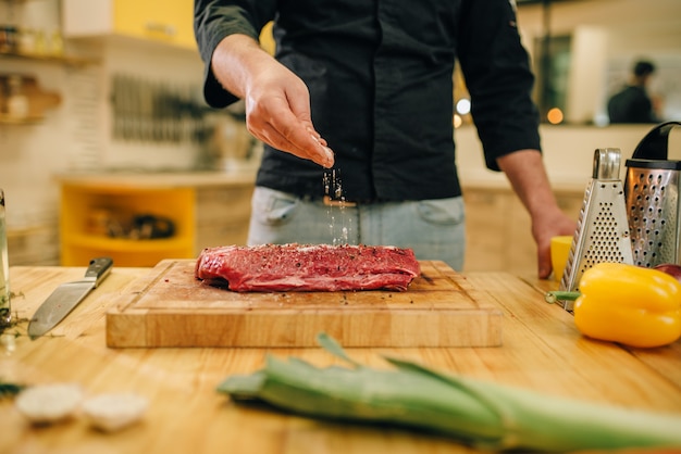 男性が生肉に調味料をふりかける