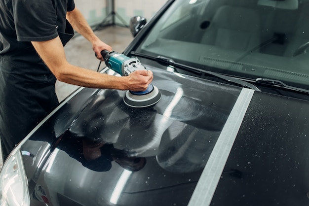 Male person with polishing machine cleans car