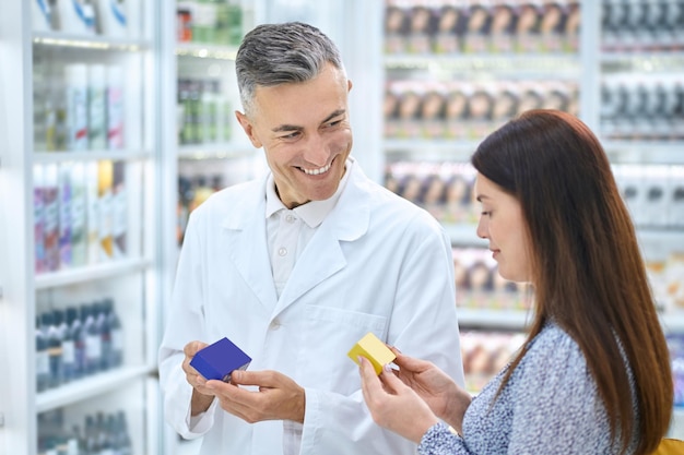 Male pharmacist consulting a customer in a drugstore