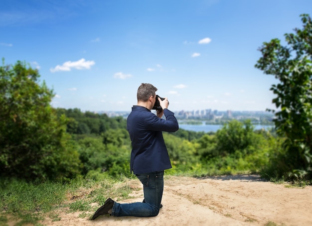 デジタルカメラで街並みの写真を撮る男性写真家