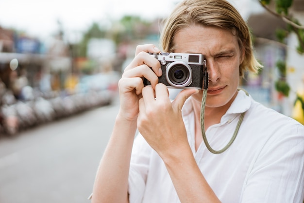 Мужской фотограф используя винтажную камеру