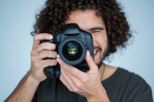 Male photographer with digital camera in studio