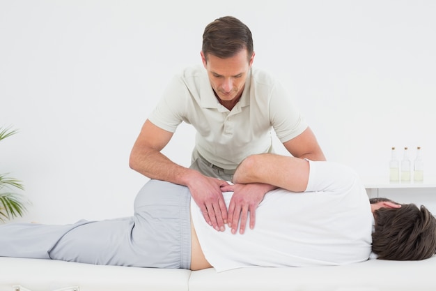 Male physiotherapist examining mans back