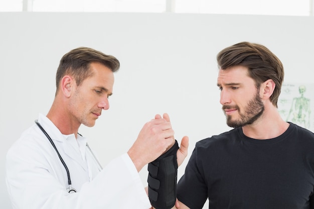 Male physiotherapist examining a mans wrist