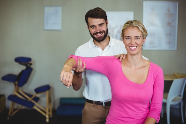 Male physiotherapist giving arm massage to female patient