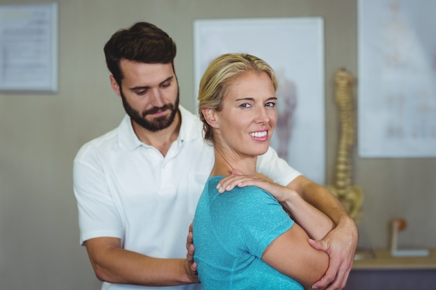 Male physiotherapist giving arm massage to female patient