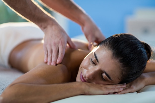 Male physiotherapist giving back massage to female patient