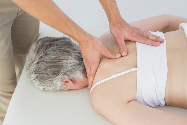 Male physiotherapist massaging a senior womans back