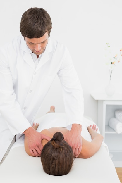 Male physiotherapist massaging womans back