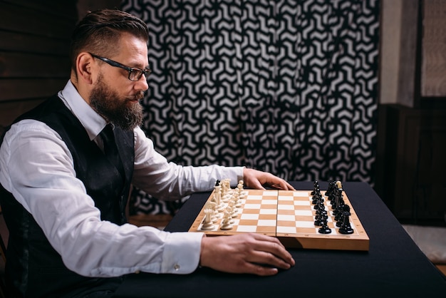 Male player against chess board with pieces set