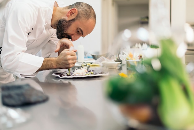 Foto cuoco unico professionista maschio che cucina in una cucina.