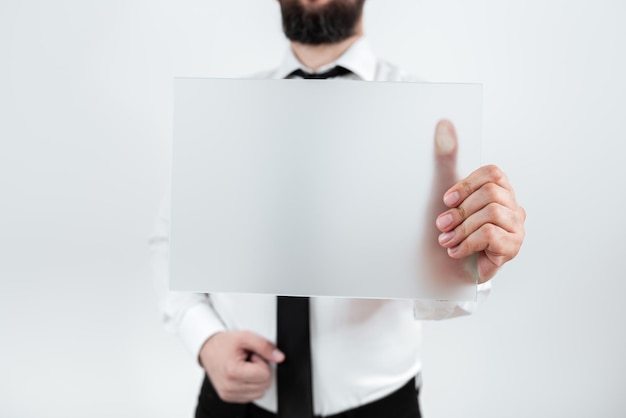 Мужчина-профессионал держит пустой плакат и показывает важные данные Бизнесмен с бумагой в руках представляет маркетинговые стратегии для развития бизнеса