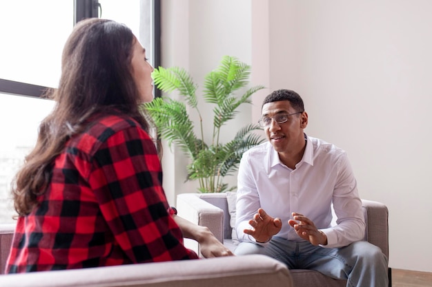 Male psychologist calms female patient at session at home specialist psychiatrist consults