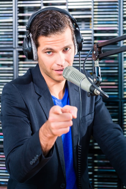 Foto presentatore radiofonico maschile nella stazione radio in onda