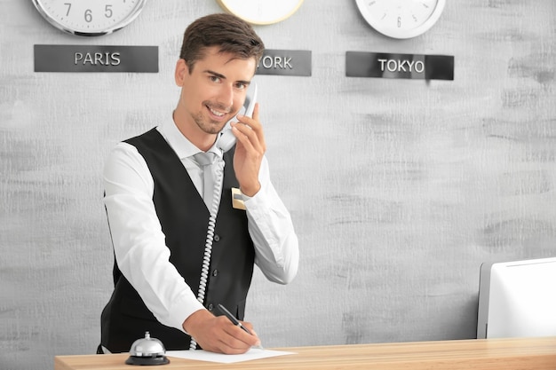 Foto receptionist maschio che lavora in hotel