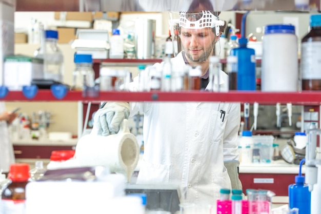 Male researcher doing research experiment in chemistry lab concept of chemist laboratory