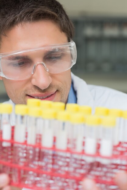 Male researcher  looking at test tubes in the lab