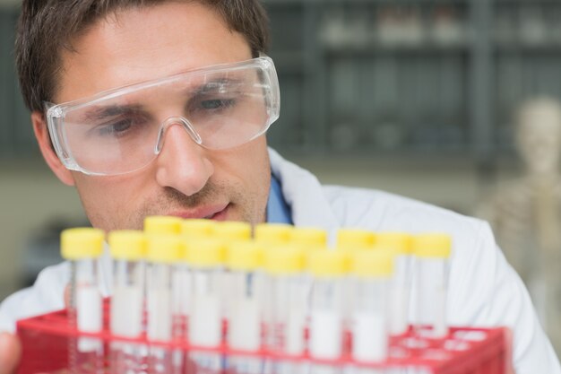 Male researcher  looking at test tubes in the lab