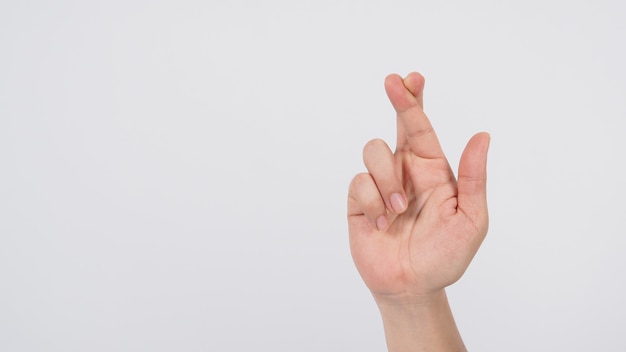 La mano destra del maschio che fa il segno incrociato delle dita su sfondo bianco.