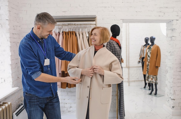 A male sales consultant serves an elderly woman in a clothing store Polite customer service