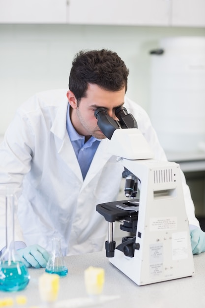 Male scientific researcher using microscope in lab