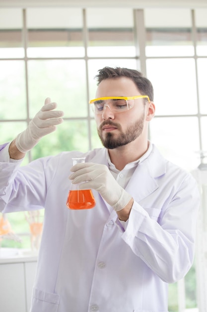 Foto scienziato maschio con un bicchiere in laboratorio