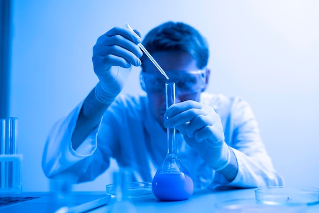 白い制服を着た男性科学者が研究室で研究をしています