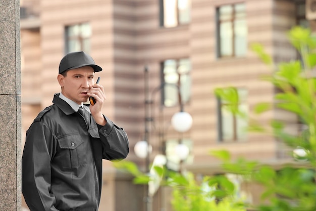 Photo male security guard with portable radio outdoors