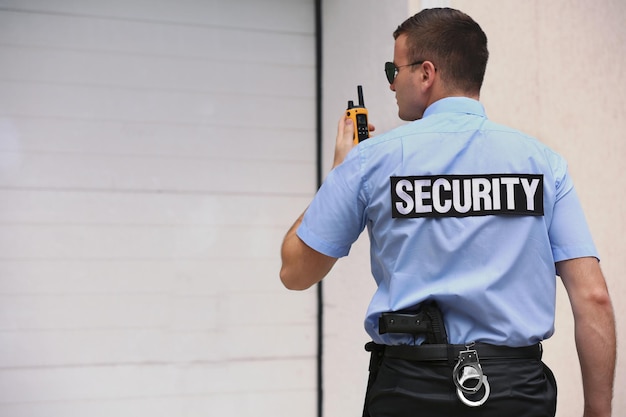 Photo male security guard with portable radio outdoors