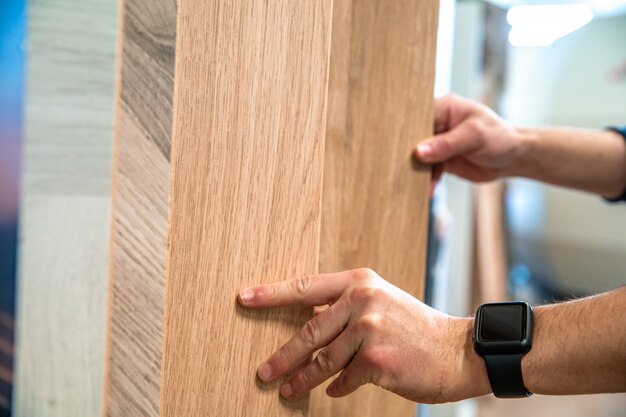 Male selects wooden floor of the sample in the specialized trade